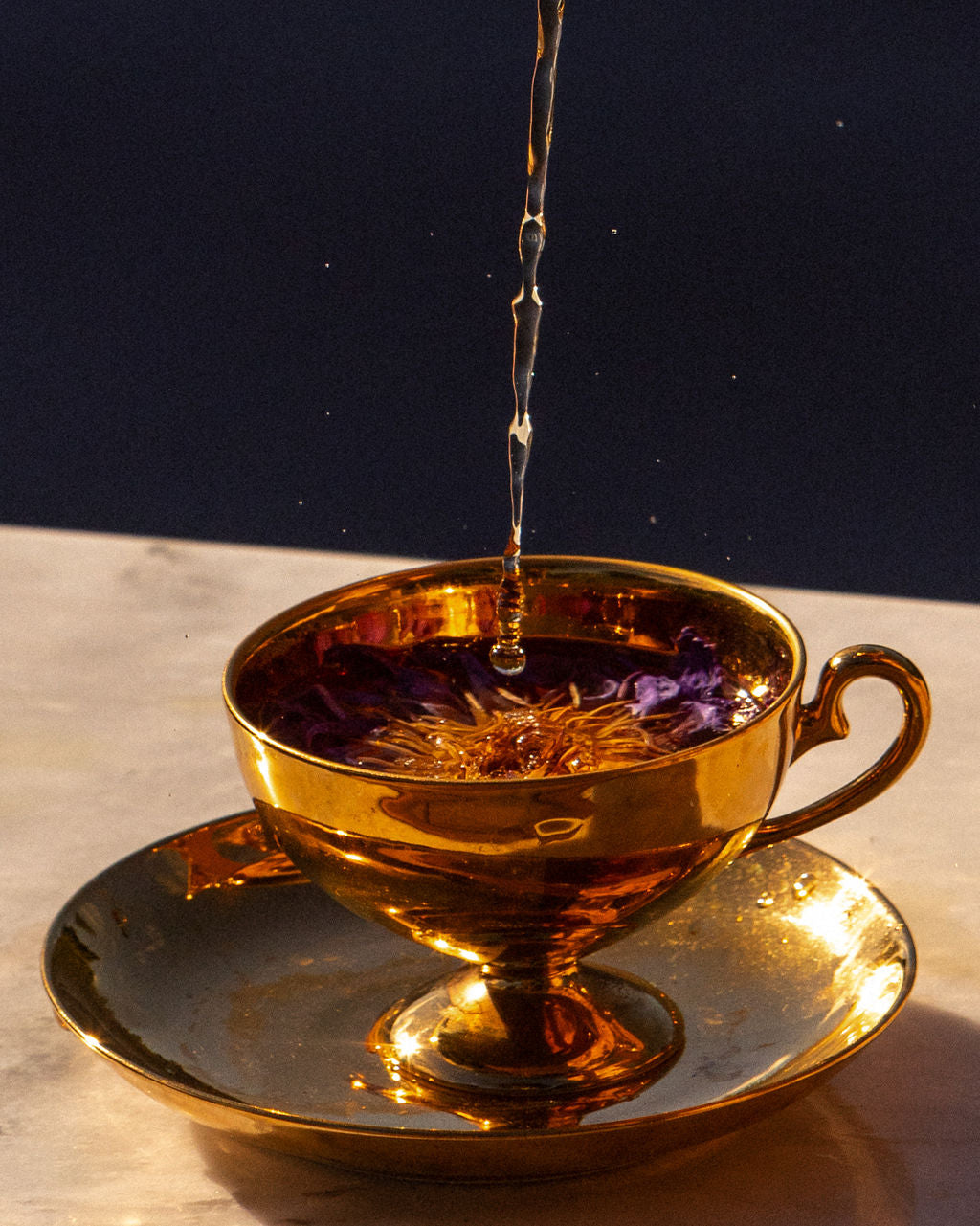 Blue Lotus tea in a gold cup, pouring blue lotus tea, new zealand