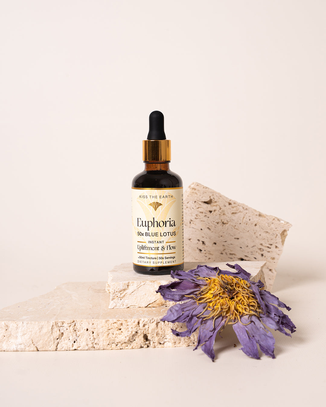 Euphoria is a blue water lily tincture made by kiss the earth in an amber bottle next to a blue lotus flower 
